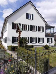 a white house with black windows and a fence at Ferienwohnung Sabrina in Aichen