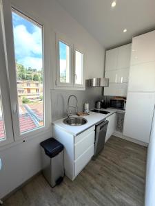 a white kitchen with a sink and a window at Palace Riviera Studio - Plages & Centre Menton in Menton