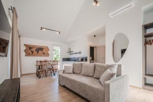 a living room with a couch and a kitchen at Topolių terasos in Palanga