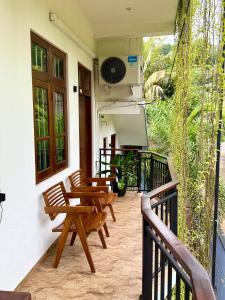 a patio with a table and chairs on a balcony at Devon Surf . Inn - Hiriketiya in Dickwella