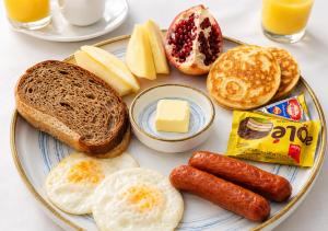 a plate of breakfast food with eggs sausage and bread at Hostel DANEXAN APA in Nukus