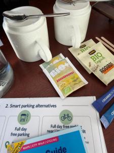 a table with two containers of food and a paper at Hotel Oorsprongpark City Centre Utrecht in Utrecht