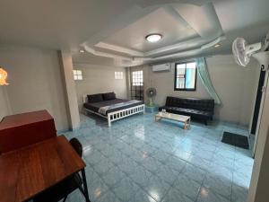 a living room with a couch and a table at Tommy Apartment - main road in Ko Tao