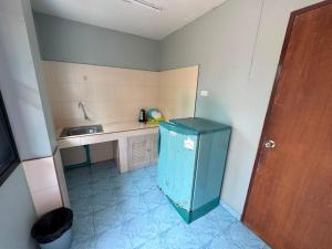 a small kitchen with a blue refrigerator and a sink at Tommy Apartment - main road in Ko Tao