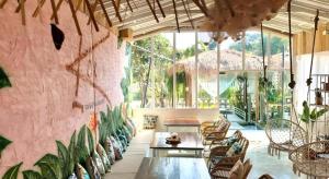 a room with chairs and tables and a pink wall at The State Resort in Ban Wat Phrik (1)