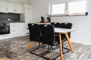 a kitchen with a wooden table and black chairs at Fewo 14 DG in Goch +3 photos