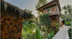 a house with a dog standing in front of it at Tamsabai Resort in Ban Na Nian