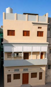 a white building with brown doors and windows at Shiv Kothi Home Stay in Varanasi