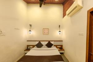 a bedroom with a bed and two lights on the wall at Shalimar in the Forest in Matheran +41 photos