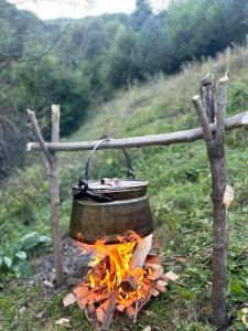 a pot sitting on top of a fire at Guesthouse Gama in Khevsureti in Roshka