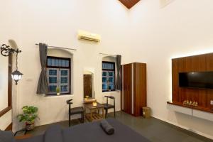 a living room with a couch and a flat screen tv at Shalimar in the Forest in Matheran
