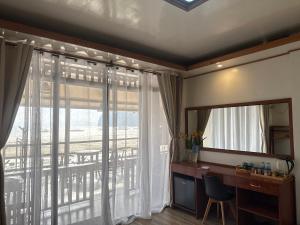 a room with a desk and a mirror and a window at Fabregas Beach Cottages in El Nido