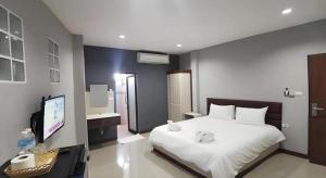 a bedroom with a white bed and a flat screen tv at Poompimaan House in Udon Border Police +75 photos