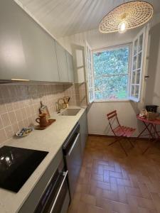 a kitchen with a counter and a sink and a window at Le Refuge du Vieux Moulin in Arles