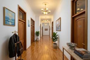 a hallway with white walls and wooden floors and a chandelier at Grand Liman Hotel in Baku