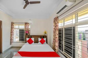 a bedroom with a bed and a large window at Hotel O Dream Marion in Bhubaneshwar +25 photos