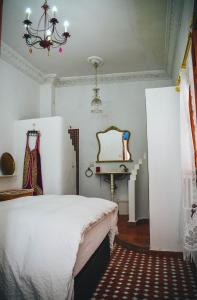 a bedroom with a bed and a table and a chandelier at Riad Tetuanía in Tétouan +71 photos