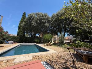 a small swimming pool in a yard with trees at Le Refuge du Vieux Moulin in Arles