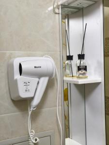 a hair dryer in a bathroom next to a mirror at Сдается квартира у Озера in Balqash
