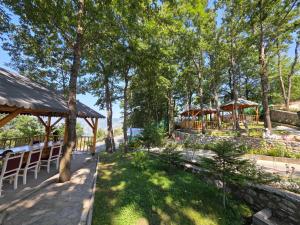 a patio with tables and chairs and trees at Hotel Restaurant Ujimira in Radomirë