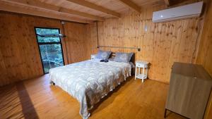 a bedroom with a bed in a room with wooden walls at Babitouli-2 in Niabauri