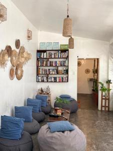 a living room with blue chairs and a book shelf at Jaydy hostel in General Luna