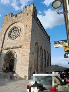 a large brick building with a clock tower at Albergue O Centro in Portomarin