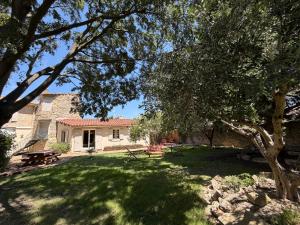 a yard with a house and a picnic table at Le Refuge du Vieux Moulin in Arles +14 photos