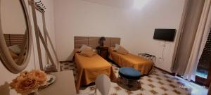 a small room with two beds and a mirror at Casa Anselmo Guest House in Pagani