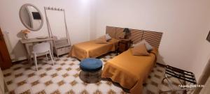 a room with two beds and a desk and a mirror at Casa Anselmo Guest House in Pagani