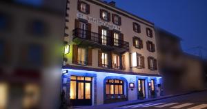 un edificio con luces azules en el lateral. en Logis Hotel restaurant de la Poste, en Pontgibaud