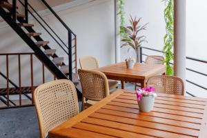 a patio with wooden tables and chairs and stairs at Ithaa Inn Kamadhoo in Baa Atoll