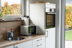 a kitchen with a microwave and a sink at Seepark Goch-Kessel in Kessel