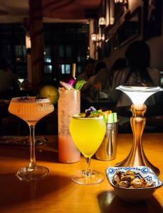a table with three cocktails and a bowl of nuts at Atour Hotel Beijing Gulou Houhai - Free Night Snacks in Beijing +44 photos