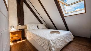 a small bedroom with a bed and a window at Duplex U Marzeny in Ostróda