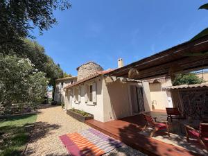 a house with a wooden deck and chairs on it at Le Refuge du Vieux Moulin in Arles