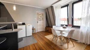 a kitchen and dining room with a table and chairs at Duplex U Marzeny in Ostróda