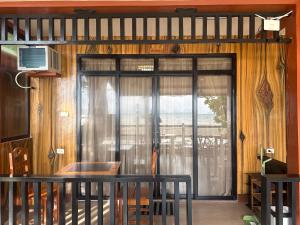 a room with a sliding glass door with a balcony at Fabregas Beach Cottages in El Nido