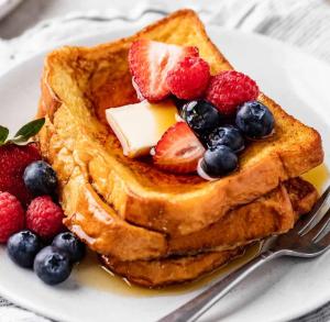 a plate of french toast with fruit and butter at Yiganda Hotel, Ethiopia in Bahir Dar
