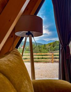 a lamp sitting next to a couch in a room with a window at Cottage Magdalena in Žabljak