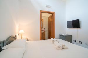 a bedroom with a white bed with towels on it at Residence Hotel Monte Ricciu Nuova Gestione in Alghero +51 photos