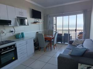 a kitchen and living room with a couch and a table at Unit 18 Kei Sands Resort in Kei-mouth Village