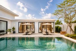 a swimming pool in front of a house at Le Da Villas 5BR Bang Tao Beach in Laguna Phuket