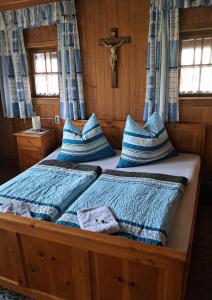 a bedroom with a large bed with blue pillows at Ferienhäuschen Rahm in Hainzenberg