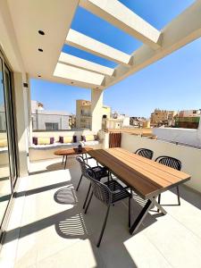 a patio with a wooden table and chairs on a roof at House 29 Suites in Heraklio