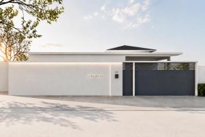 a white house with a black garage at Le Da Villas 5BR Bang Tao Beach in Laguna Phuket