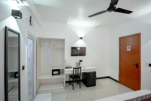 a living room with a ceiling fan and a desk at Cozy Roots Fuvahmulah in Fuvahmulah
