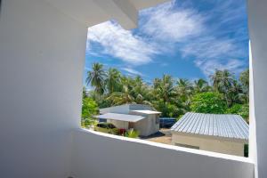a view from a window of a building with palm trees at Cozy Roots Fuvahmulah in Fuvahmulah +14 photos