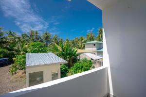 a view from the balcony of a house with palm trees at Cozy Roots Fuvahmulah in Fuvahmulah