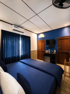 a bedroom with a large blue bed and a television at 87 Ahangama in Ahangama